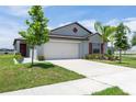 Well-maintained single-Gathering home with a lush green lawn, landscaping, and a two-car garage at 9805 Lemon Drop Loop, Sun City Center, FL 33573