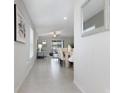 Bright hallway leading to an open floorplan with a dining table and living area at 9805 Lemon Drop Loop, Sun City Center, FL 33573