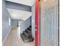 Bright entryway features tile flooring, gray walls, staircase to the second level, and a decorative red front door at 10815 Wrigley Ct, Riverview, FL 33579