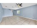 Spacious living room features tile flooring, neutral paint, a ceiling fan, and a view of the staircase at 10815 Wrigley Ct, Riverview, FL 33579