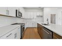 Bright kitchen with white cabinetry, stainless steel appliances, quartz countertops, and wood flooring at 12660 Glenn Creek Dr, Riverview, FL 33569