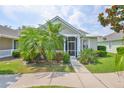 Cozy home with well-maintained landscaping, featuring a screened-in porch, a palm tree, and healthy green lawns at 217 Oceania Ct, Apollo Beach, FL 33572