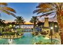 Resort-style pool with a charming lighthouse structure and water slide, surrounded by palm trees and a tranquil lake at 217 Oceania Ct, Apollo Beach, FL 33572