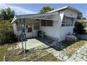 Exterior view of a cozy, single-story home with a covered porch, front door, and small landscaped area at 37402 Hammond Dr, Zephyrhills, FL 33541