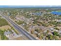 Expansive aerial view of a residential area with mature trees, multiple lakes, and a long highway at 6009 County Line Rd, Spring Hill, FL 34606