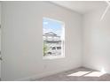 Bright bedroom features a neutral carpet, white walls, and a window offering an outdoor view at 6212 Broad Field Ave, Apollo Beach, FL 33572