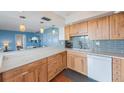 Bright kitchen with light wood cabinets, stainless steel appliances, and a breakfast bar overlooking the living area at 6051 Sun Blvd # 504, St Petersburg, FL 33715