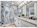 Elegant bathroom with a double sink vanity, marble countertop, and a glass-enclosed walk-in shower with pebble floor at 11624 Monette Rd, Riverview, FL 33569