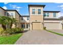 Charming townhome featuring a two-car garage, well-maintained landscaping, and a welcoming entrance at 29913 Southwell Ln, Wesley Chapel, FL 33543