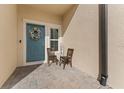 Cozy front porch with decorative wreath, outdoor seating, and a welcoming autumn sign at 29913 Southwell Ln, Wesley Chapel, FL 33543