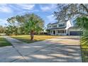Two-story home with a well-manicured lawn, palm trees, and a spacious driveway leading to a two-car garage at 3870 155Th E Ave, Parrish, FL 34219