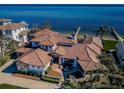 Stunning aerial view of a Mediterranean-style home on the water with a tiled roof and lush landscaping at 3901 Bayshore Ne Blvd, St Petersburg, FL 33703