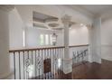 Elegant foyer with hardwood floors, decorative columns, wrought iron railing, and a stylish chandelier at 5020 W Dickens Ave, Tampa, FL 33629
