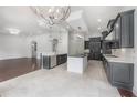 Modern kitchen with sleek gray cabinets, stainless steel appliances, quartz counters, and a large island at 5020 W Dickens Ave, Tampa, FL 33629