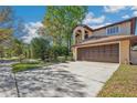 Two-story home with an attached two-car garage and a large driveway, shaded by mature trees at 513 Suwanee Cir, Tampa, FL 33606