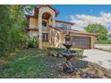 Beautiful home showcasing manicured landscaping, an elegant fountain, and a welcoming arched entryway at 513 Suwanee Cir, Tampa, FL 33606