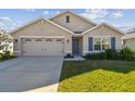 Charming single-story home featuring a two-car garage and well-maintained lawn with blue shutters and a welcoming entrance at 12143 Kingsley Trl, Parrish, FL 34219