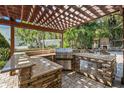 This outdoor kitchen features stone accents, stainless steel appliances and a built-in grill at 5701 S Macdill Ave, Tampa, FL 33611