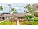 Inviting single-story home featuring well-maintained landscaping and a quaint front porch area at 10 Aster Pl, Oldsmar, FL 34677