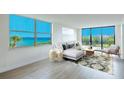 Bright living room features hardwood floors, a modern sofa, and expansive windows with ocean views at 100 Oakmont Ln # 309, Belleair, FL 33756