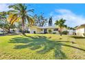 Inviting single-Gathering home with a lush green lawn and swaying palm trees, perfect for Florida living at 2589 Redwood Cir, Clearwater, FL 33763