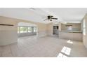Bright, spacious living room with tile flooring, ceiling fan, and open access to an adjacent sunroom at 8839 W Millpoint Rd, Riverview, FL 33578