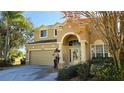 Attractive residence featuring mature landscaping, a two-car garage, and covered entryway at 8999 Founders Cir, Palmetto, FL 34221