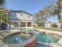 Backyard pool and jacuzzi with outdoor living space, perfect for relaxing and entertaining in a tropical setting at 1600 Pennsylvania Ne Ave, St Petersburg, FL 33703