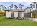 A single-story house with a well-manicured lawn and a two-car garage at 3355 Moncrief Ave, North Port, FL 34286