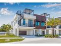 Modern three-story townhome with a rooftop deck, spiral staircase, and wood accents, complemented by lush landscaping at 460 87Th Avenue North, St Petersburg, FL 33702