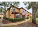 Charming condo exterior with tan and red accents, featuring lush landscaping and a welcoming walkway at 2254 Chianti Pl # 68, Palm Harbor, FL 34683