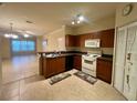 Well-lit kitchen featuring dark wood cabinets, white appliances, and tile flooring at 2254 Chianti Pl # 68, Palm Harbor, FL 34683