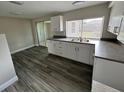 Bright kitchen features stainless steel appliances, white cabinets, and wood-look floors at 3341 Wiltshire Dr, Holiday, FL 34691