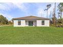 Expansive backyard featuring a lush lawn and the rear exterior of a modern home at 4294 Danbury St, North Port, FL 34286