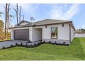 Charming single-story home showcasing a well-manicured lawn and a gray two-car garage at 4294 Danbury St, North Port, FL 34286