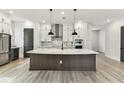 Modern kitchen featuring stainless steel appliances, a large island, and stylish pendant lighting at 441 42Nd Ne Ave, St Petersburg, FL 33703