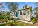 Quaint home with a blue front door, bright windows, and lush garden beds creating a welcoming entrance at 5053 3Rd N Ave, St Petersburg, FL 33710