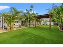 Lush backyard with tropical landscaping, artificial turf, and a covered pergola at 4210 Harrisburg Ne St, St Petersburg, FL 33703