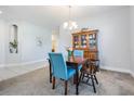 Inviting dining area with a wooden table, blue upholstered chairs, neutral walls, and carpet flooring at 19724 Post Island Loop, Land O Lakes, FL 34638