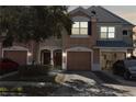 Charming multi-story townhome featuring an attached garage and well-maintained landscaping at 26614 Castleview Way, Wesley Chapel, FL 33544