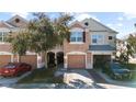Charming two-story townhome with a one-car garage, landscaped front yard, and welcoming curb appeal at 26614 Castleview Way, Wesley Chapel, FL 33544