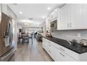Modern kitchen with white cabinets, gray backsplash, stainless steel appliances, and black countertops at 3010 59Th S St # 304, Gulfport, FL 33707