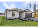 Lovely single-story home featuring an attached two-car garage and beautiful landscaping with lush green lawn at 3560 Bellefonte Ave, North Port, FL 34286