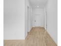 Bright hallway featuring light wood-look floors, white walls and trim, and recessed lighting offering a clean design at 3560 Bellefonte Ave, North Port, FL 34286