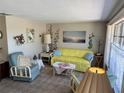 Bright living room with a vibrant yellow sofa, accent chairs, and floral decor at 3722 Haven Dr, New Port Richey, FL 34652