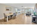 Open-concept living and dining area boasts wood floors, a dining table with four chairs, and ample natural light at 4519 S Hesperides St, Tampa, FL 33611