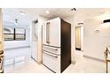 Modern kitchen features updated stainless steel refrigerator and appliances with large, bright tile flooring at 5400 Park N St # 209, St Petersburg, FL 33709