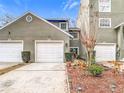 A multi-unit home featuring well-manicured landscaping, white garage doors and a neutral, well-maintained exterior at 5832 Red Cedar Ln, Tampa, FL 33625