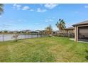 Expansive backyard with green grass and fenced waterside views, perfect for outdoor enjoyment and relaxation at 6216 Kevesta Ave, Palmetto, FL 34221