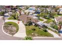 Expansive aerial view of a single-story home featuring a large driveway, lush landscaping, and a private backyard pool at 911 Boca Ciega Isle Dr, St Pete Beach, FL 33706